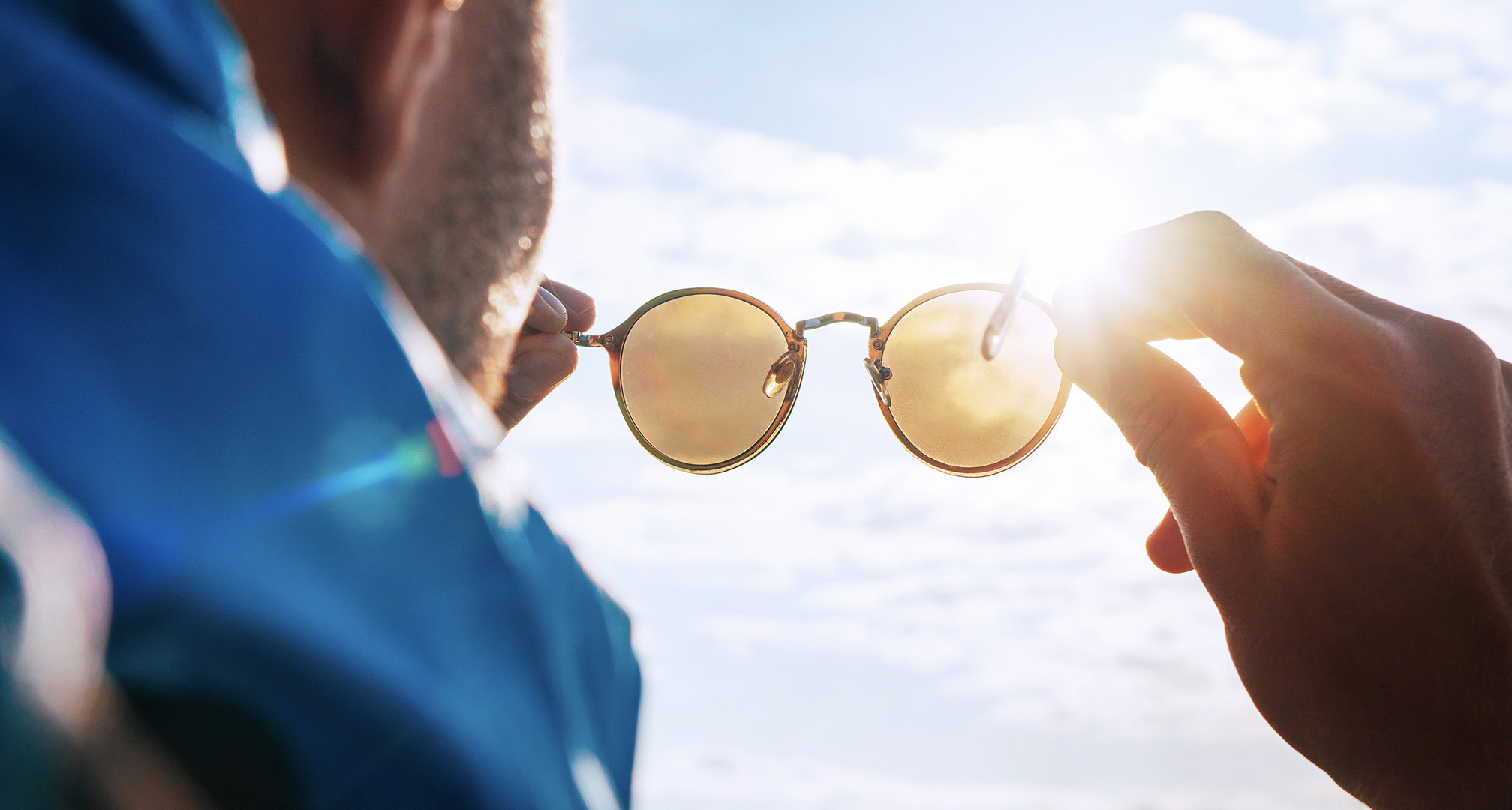 pitää aurinkolaseja aurinkoa vasten