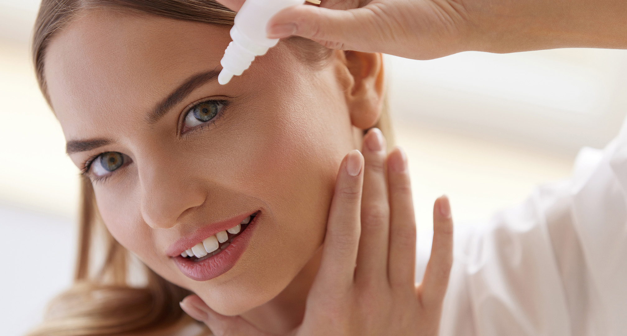 henkilö annostelee silmätippoja