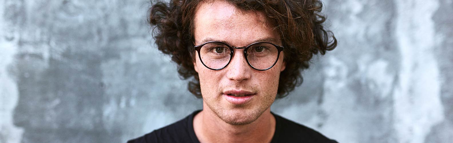 Henkilö, jolla on naarmuuntuneet silmälasit