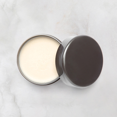 Purkki valkoista vahaa neutraalilla taustalla